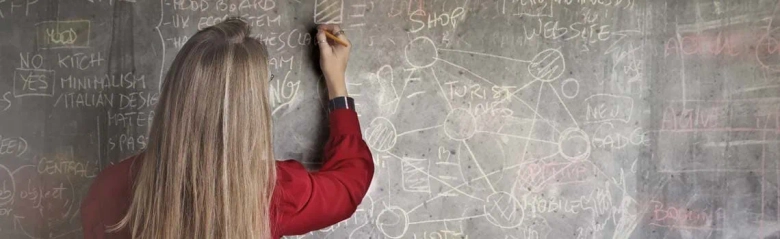 A teaching assistant writing on a blackboard