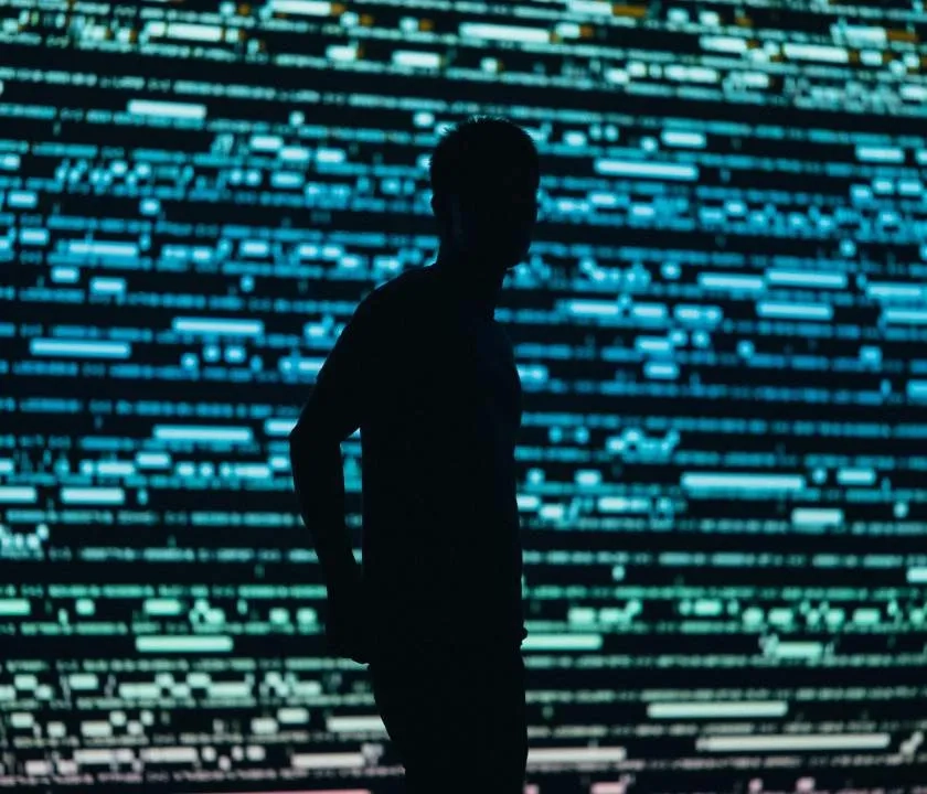 Silhouette of a person against a digital background.